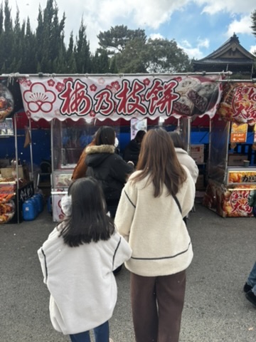 嫁と子供が赤間神宮の梅ヶ枝餅の屋台に向かう写真