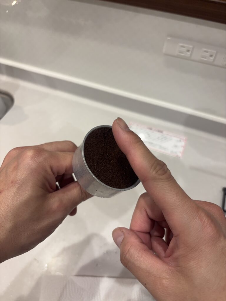 ブリッカのバスケットから溢れたコーヒー粉をすりきっている写真